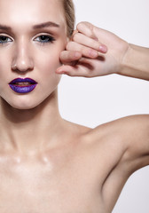 Naklejka premium Beauty portrait of young woman with violet lips makeup