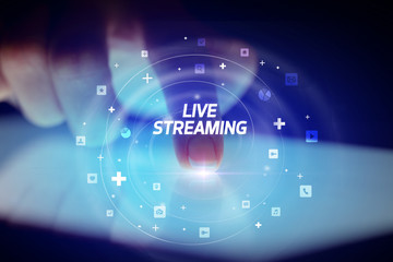 Finger touching tablet with social media icons and LIVE STREAMING