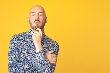 Fabulous at any age. Portrait of 40-year-old man standing over light yellow background in blue...