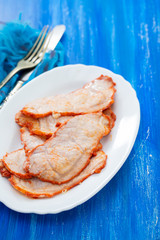 fried meat on white dish on blue wooden background
