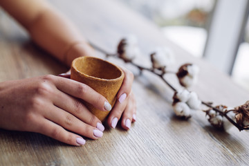 Empty waffle Cup for ice cream in hands in cafe.Wafer cup for ice-cream in hand with space for text.advertising waffle Cup.empty cardboard glass with coffee in female hand.