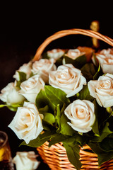white roses in a basket on a black background