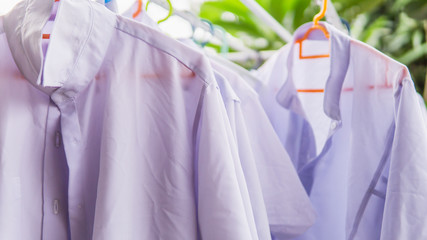 Close up view of the white school uniform for the students drying under the sun on the outdoor...