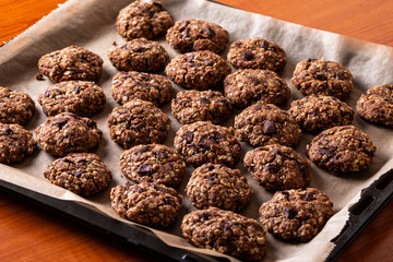 Chocolate cookies on wooden table with cinnamon sticks. Autumn style food photo.
