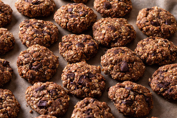 Chocolate cookies on wooden table with cinnamon sticks. Autumn style food photo. Close-up macro.