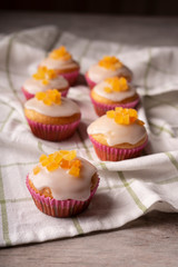 Candied fruit orange muffins on a white towel.