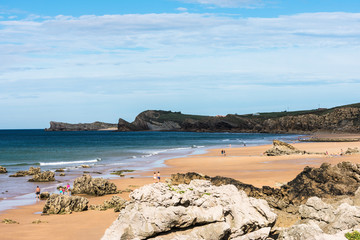 view of the beach with rocks and sand between cliffs