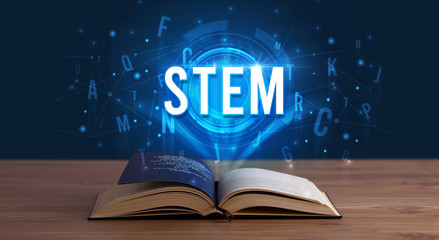 STEM inscription coming out from an open book, digital technology concept