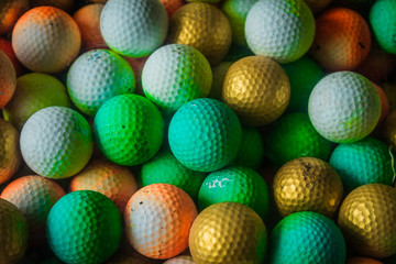 A colorful of old white golf ball which keep in a golf tray.