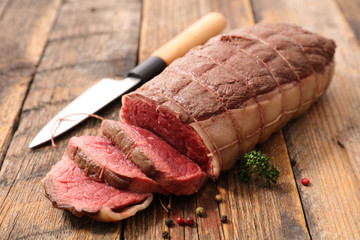 roast beef slices on wood background