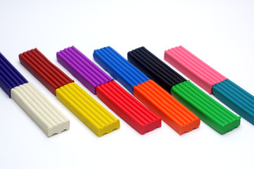 Multicolored set of plasticine sticks on white background.