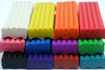 Multicolored set of plasticine sticks on white background closeup view.