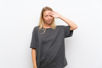 Blonde young woman over isolated white background with tired and sick expression