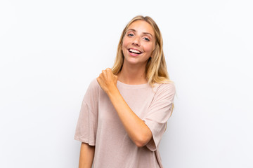 Blonde young woman over isolated white background celebrating a victory