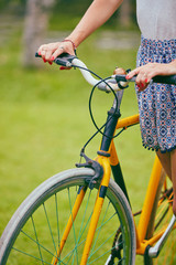 Obraz premium Pretty woman standing with old bicycle outdoors.