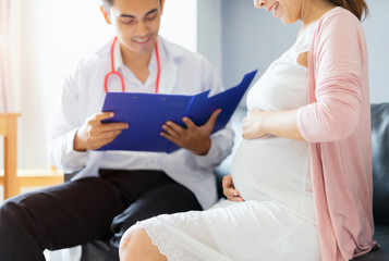 Happy pregnant woman visit doctor at hospital for pregnancy consultant at ultrasound scanning office