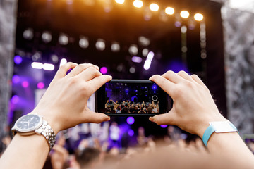 Smartphone in hands on music show.