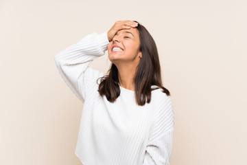 Young brunette woman with white sweater over isolated background laughing