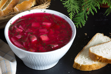 Close up beetroot soup in white bowl on black background