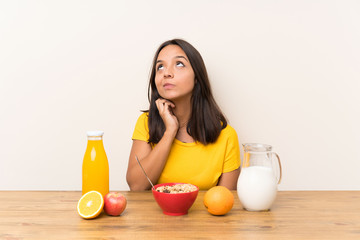 Young brunette girl having breakfast milk thinking an idea