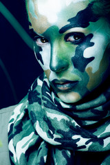 Beautiful young fashion woman with military style clothing and face paint make-up, khaki colors, halloween celebration