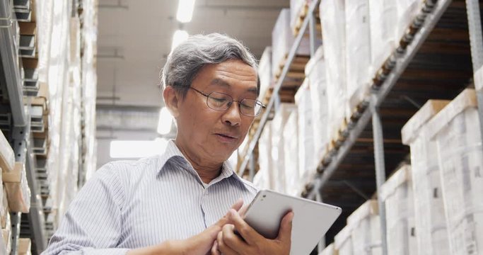 Businessman using tablet for working at warehouse. Business and Technology concept.