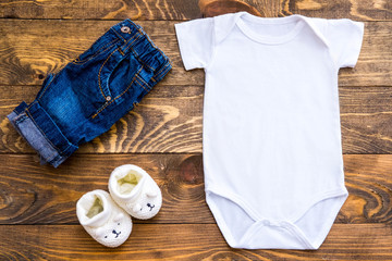 Mockup of white baby bodysuit shirt, slippers and jeans