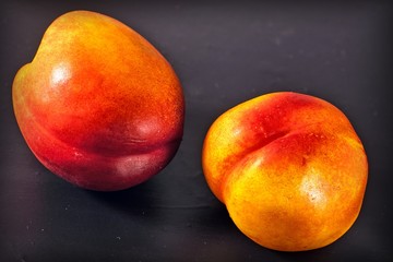two nectarines on black background