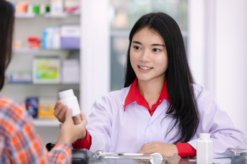 asian female pharmacist and female patients in pharmacy  health care concept in Thailand
