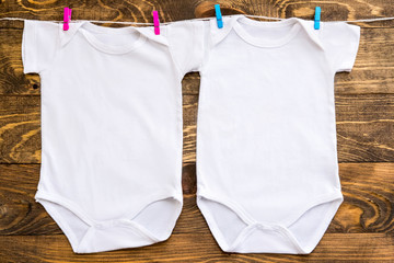 Mockup of two white baby bodysuit shirt