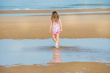 Fototapeta na wymiar beautiful young girl walking on the beach
