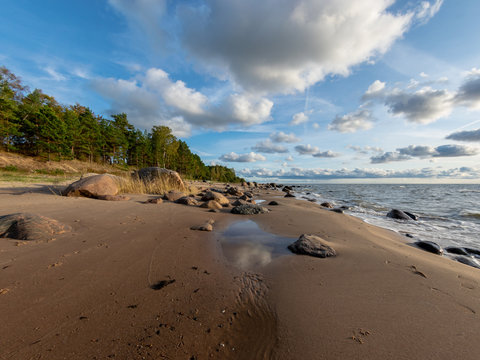 seascape image of the sea with cloudy sky before sunset,  stones and  of light before sunset, beautiful sunny day and quiet sea. baltic sea, Tuja beatch, Latvia