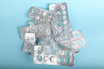 medical blisters packs opened and empty without pills top view on blue background. Medical concept of treatment diseases, sale of tablets, tablets in blister packs,addiction from drugs