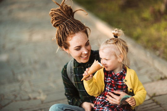 Mom And Daughter Together Eat Ice Cream In Park