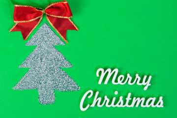 Glitter christmas tree  with merry christmas words on green background, christmas card with copy space