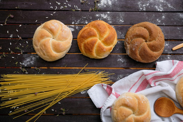  three hot cross buns made from different flour on a wooden table