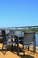 Outdoor tables and chairs, empty beach restaurant table by the river