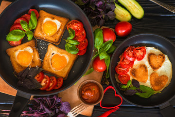 fried eggs heart-shaped breakfast on a black background