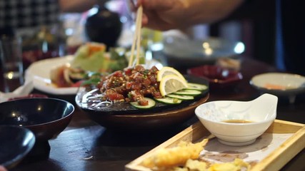Eating spicy salmon salad in Japanese restaurant