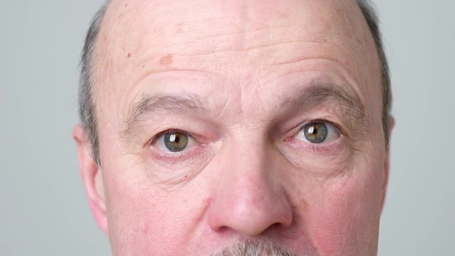 Mature hispanic man doing special exercises for eyes health focusing in different points. Gymnastics for eyesight. Up down variation