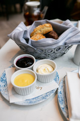 Scones at high tea with mascarpone, lemon curd, and jam