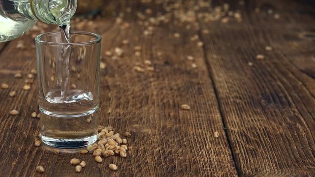 Pouring in a wheat liqueur shot (4K UHD footage)