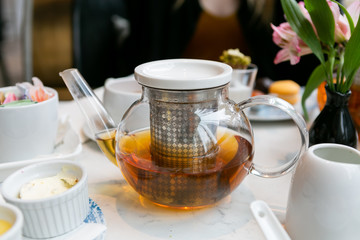 glass teapot with earl grey tea on table at high tea