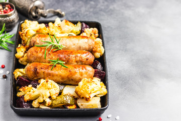 Sheet pan dinner, baked vegetables, turkey sausages. Selective focus, copy space.
