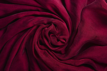 Soft smooth burgundy silk fabric background. Fabric texture.