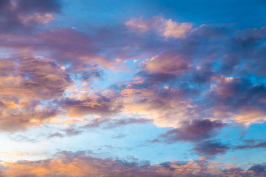 Colorful image of dramatic cloudscape. Amazing clouds of pink, purple, violet, white, gray color on the background of the evening dark sky after sunset.