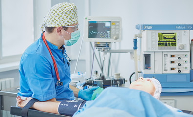 Several doctors surrounding patient on operation table during t