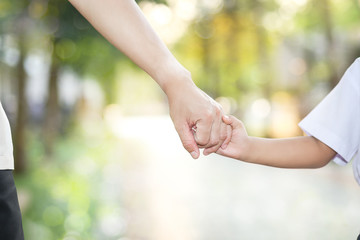 Father and son holding hands walking together in a school.