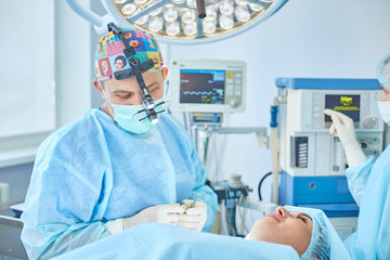 Several doctors surrounding patient on operation table during t