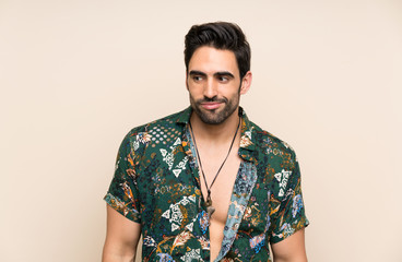 Handsome man in summer shirt over isolated background standing and looking to the side